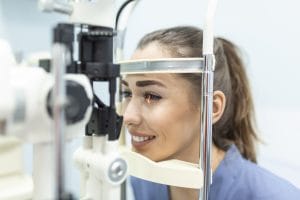 Eye doctor with female patient during an examination in modern clinic. Ophthalmologist is using special medical equipment for eye health